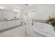 Bathroom features a soaking tub, double sink vanity with granite counters, and tile flooring at 325 Wynland Trce, Sandy Springs, GA 30350