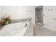 Bathroom featuring a soaking tub, glass shower, and ceramic tile accents at 325 Wynland Trce, Sandy Springs, GA 30350