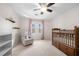 Neutral bedroom with a ceiling fan, crib, glider chair, and natural light at 325 Wynland Trce, Sandy Springs, GA 30350