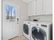 Bright laundry room featuring white cabinets, washer and dryer, and access to back yard at 325 Wynland Trce, Sandy Springs, GA 30350