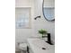 Bright bathroom featuring a modern sink, matte black hardware, and a large, round mirror at 4013 Oglesby Rd, Powder Springs, GA 30127