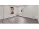 Bright bedroom featuring modern gray wood floors, two windows, and a white door at 819 Humphries St, Atlanta, GA 30310