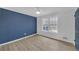 Bedroom with wood floors, blue accent wall, and large windows at 137 Creekview Dr, Woodstock, GA 30188