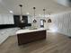 Modern kitchen with white cabinets, a central island with pendant lighting, and wood grain flooring at 137 Creekview Dr, Woodstock, GA 30188