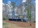 A back exterior view with a deck and gray chimney, surrounded by a wooded landscape at 137 Creekview Dr, Woodstock, GA 30188