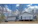 Exterior rear elevation featuring a deck with stairs leading to the yard and a small storage shed at 137 Creekview Dr, Woodstock, GA 30188