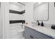 Bathroom with marble countertop, gray vanity, black fixtures, and tiled shower at 2712 Stargazer Ter, Smyrna, GA 30080