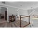 Upstairs hallway with gray wood floors, white trim, and three open doorways at 4350 White Surrey Nw Dr, Kennesaw, GA 30144