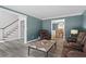 Inviting living room with gray wood floors, blue walls and a view into the dining room at 4350 White Surrey Nw Dr, Kennesaw, GA 30144