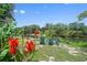 Backyard with red flowers overlooking the river, and three blue Adirondack chairs at 6090 River Chase Cir, Atlanta, GA 30328