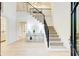 Bright foyer featuring a grand staircase with iron railings, light hardwood floors, and modern chandelier at 6090 River Chase Cir, Atlanta, GA 30328