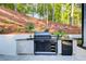 Outdoor kitchen features built-in grill, counter space, beverage cooler, and hillside view at 6090 River Chase Cir, Atlanta, GA 30328