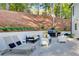 Outdoor patio featuring lounge chairs, sofa seating, grill, and retaining wall with mature landscaping at 6090 River Chase Cir, Atlanta, GA 30328