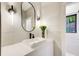 Modern powder room featuring a sleek vanity, unique mirror, stylish lighting, and natural light at 6090 River Chase Cir, Atlanta, GA 30328