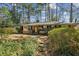 Exterior of a charming brick home with a walkway surrounded by greenery and mature trees at , Atlanta, GA 30329