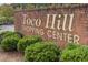 Toco Hills Shopping Center sign in a brick wall with green bushes in the front at , Atlanta, GA 30329