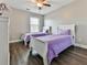 Charming bedroom featuring two twin beds with purple comforters, ceiling fan at 301 Cochin Dr, Woodstock, GA 30188