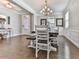 Open concept dining room with hardwood floors, modern chandelier, and abundant natural light at 301 Cochin Dr, Woodstock, GA 30188