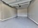 Clean, empty garage with epoxy flooring, white walls, and an open ceiling, ready for storage or projects at 301 Cochin Dr, Woodstock, GA 30188