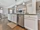 Kitchen island with stainless steel dishwasher, granite counters, white cabinets and hardwood flooring at 301 Cochin Dr, Woodstock, GA 30188