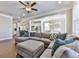 Open-concept living room with a sectional sofa, hardwood floors, and adjacent kitchen and dining areas at 301 Cochin Dr, Woodstock, GA 30188