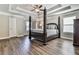 Main bedroom with a tray ceiling, four-poster bed, and hardwood floors at 301 Cochin Dr, Woodstock, GA 30188