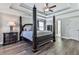 This main bedroom features a tray ceiling, four-poster bed, and wood-look floors at 301 Cochin Dr, Woodstock, GA 30188