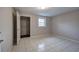 Neutral-toned bedroom featuring tiled floors, a window, and an open closet at 429 Old Tennessee Ne Hwy, White, GA 30184