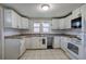 Efficient kitchen with white appliances and cabinetry plus tile floors at 429 Old Tennessee Ne Hwy, White, GA 30184