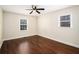 Neutral bedroom featuring hardwood floors, two windows, and ceiling fan at 5498 Stoneybrook Se Ct, Mableton, GA 30126