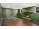 Living room showcasing green painted brick fireplace, wood floors, and natural light from windows at 5498 Stoneybrook Se Ct, Mableton, GA 30126