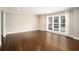 An empty living room features hardwood floors and a large bright window at 5498 Stoneybrook Se Ct, Mableton, GA 30126