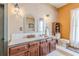 Bathroom featuring a double vanity, tiled countertops, decorative mirrors, and warm-toned walls at 1118 Glenwood Se Ave, Atlanta, GA 30316