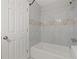 Bathroom features neutral tones with marble tile and a white bathtub at 144 Grayland Hills Ct, Lawrenceville, GA 30046