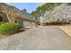Home exterior featuring an attached garage, a long driveway, and a basketball court at 3287 Belmont Glen Se Dr, Marietta, GA 30067
