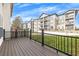 Wooden back porch with black metal railings overlooking a green space and apartment buildings at 1868 Appaloosa Mill Ct, Buford, GA 30519