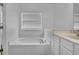 Bright bathroom showcasing a white tub under a window with blinds and a vanity with a sink at 1868 Appaloosa Mill Ct, Buford, GA 30519