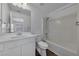 Well-lit bathroom featuring a combined tub and shower with white tiling and modern fixtures at 1868 Appaloosa Mill Ct, Buford, GA 30519