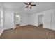 Bright bedroom with ceiling fan, neutral walls, carpet flooring, and ensuite bathroom entrance at 1868 Appaloosa Mill Ct, Buford, GA 30519