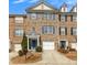 Charming brick townhome with blue shutters, a white garage, and well-maintained landscaping at 1868 Appaloosa Mill Ct, Buford, GA 30519