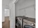 Laundry area with modern washer and dryer units, and wire shelving for storage at 1868 Appaloosa Mill Ct, Buford, GA 30519