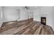 Open-concept living room with modern fireplace, wood-look floors, and staircase at 1868 Appaloosa Mill Ct, Buford, GA 30519