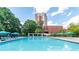 Enjoy the community pool with surrounding lounge chairs and a lush landscape, and a tall building in the background at 375 Ralph Mcgill Ne Blvd # 807, Atlanta, GA 30312