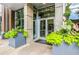 Building entrance with glass doors, decorative plants, and modern architectural details at 855 Peachtree Ne St # 2912, Atlanta, GA 30308
