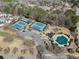 Aerial view of a community pool, tennis courts, mature trees, and clubhouse at 1091 Dunedin Trl, Woodstock, GA 30188