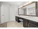 Main bathroom featuring a double vanity with dark cabinetry, large mirror, and tile flooring at 1091 Dunedin Trl, Woodstock, GA 30188