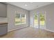 A dining area with gray cabinets, a large window, and a glass door leading to the outside is bright and airy at 1516 Montauk Pt, Conyers, GA 30013
