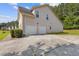Spacious two-car garage with a long driveway and landscaped shrubbery at 1516 Montauk Pt, Conyers, GA 30013