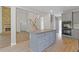 A large kitchen with an island, gray cabinets and stainless steel appliances is open to a living space with a stone fireplace at 1516 Montauk Pt, Conyers, GA 30013