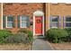 Charming brick home featuring a welcoming red door with decorative wreath and classic shuttered windows at 265 Winding River Dr # G, Sandy Springs, GA 30350